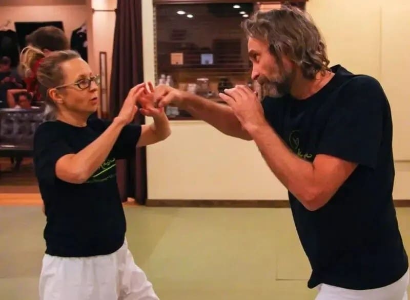 Adults practice standing self-defense techniques during brazilian jiu jitsu classes for beginners and advanced students.