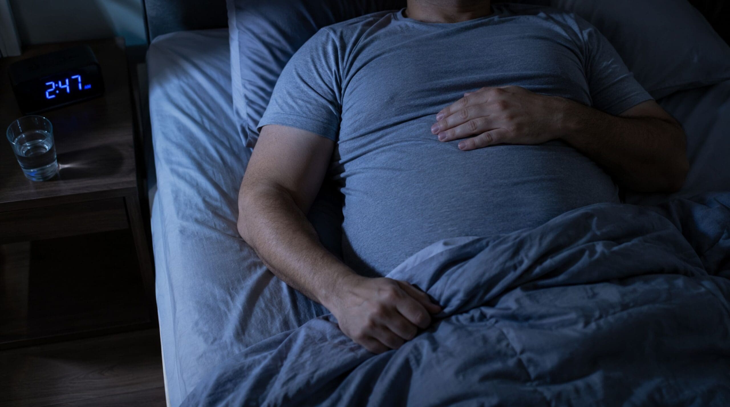 Person lying awake at night showing how poor sleep can slow weight loss despite regular exercise