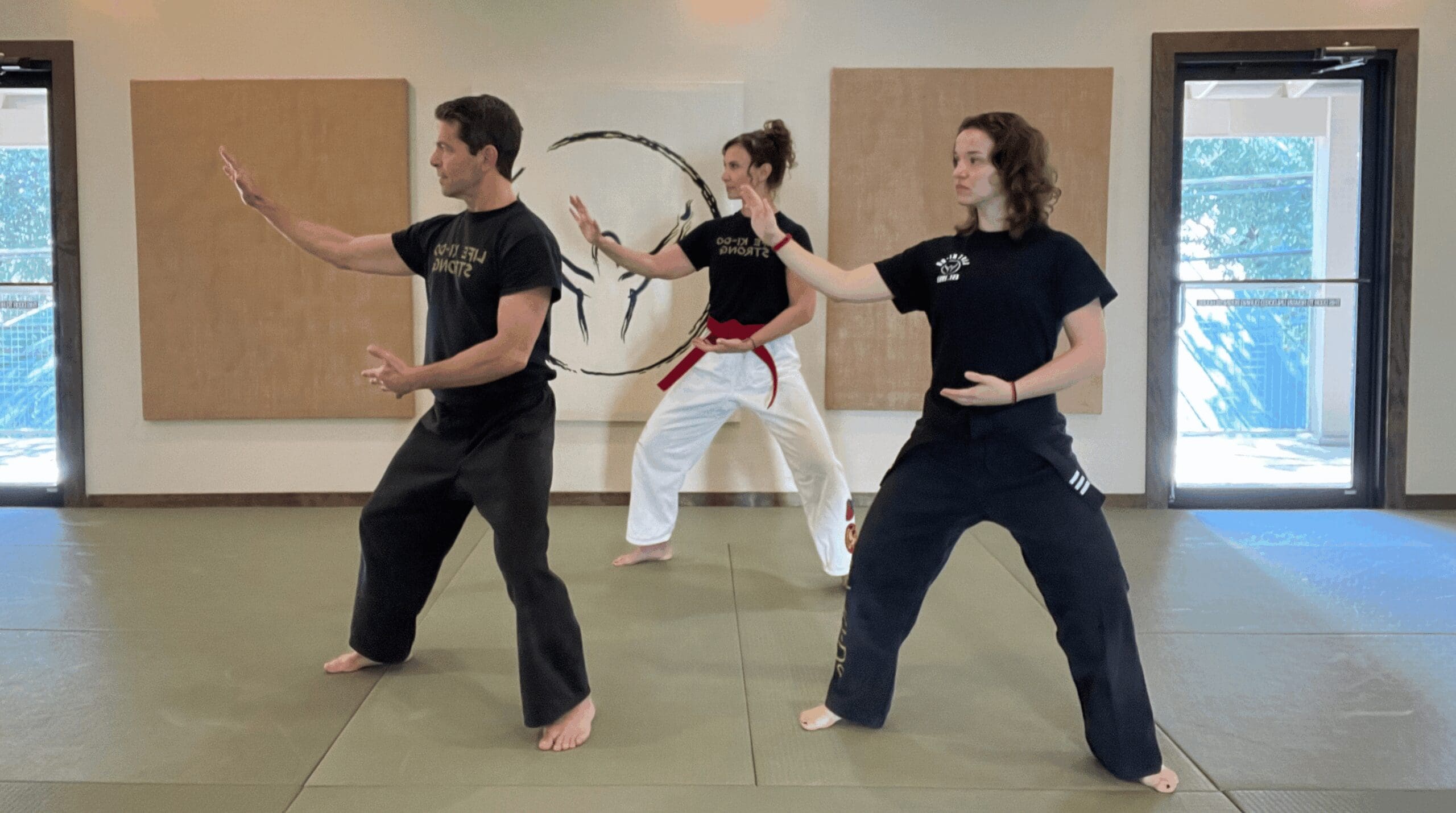 Adults practicing Tai Chi together in a martial arts class to improve balance, flexibility, and lifelong health.