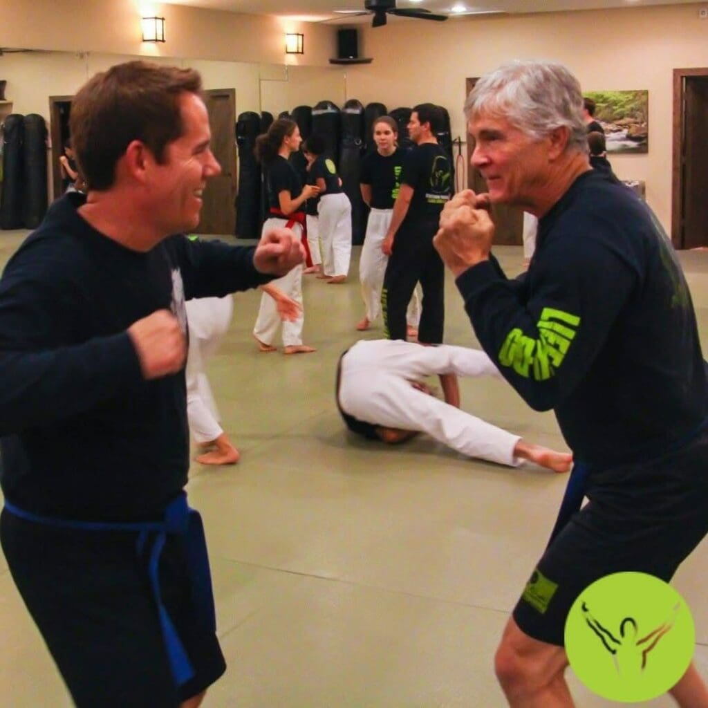 Two adult students practicing defensive stance and movement during a martial arts class that supports skills used in ground fighting in Brazilian Jiu Jitsu.